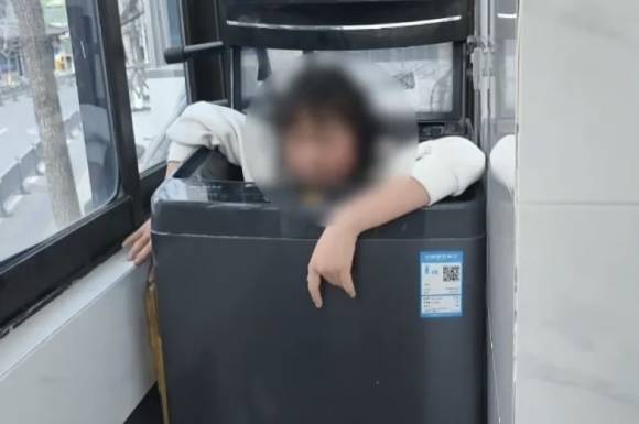 숙제 문제로 어머니와 다툰 후 세탁기 안으로 들어간 소녀. 중국 포털사이트 QQ.com 캡처