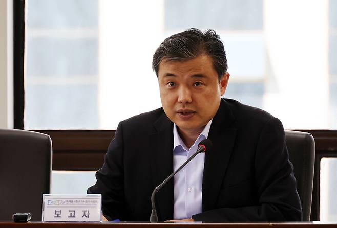 황인수 진실화해위 조사1국장이 2023년 10월17일 열린 제64차 전체위원회에서 안경과 마스크를 쓰지 않고 보고하는 모습. 황 국장은 이 사진이 촬영된 이후 전체위에서 마스크와 안경을 쓰기 시작했다. 신소영 기자 viator@hani.co.kr