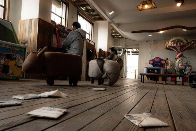 전주난장 군산극장 테마관 '전통놀이터'에서 어른 관람객이 추억의 게임을 하고 있다.