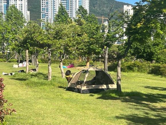 부산시설공단은 오는 12일부터 부산시민공원 전역에 그늘막 텐트 설치를 허용한다고 9일 밝혔다. 사진은 지난해 방문객이 부산시민공원에 그늘막 텐트를 설치하고 휴식하는 모습.