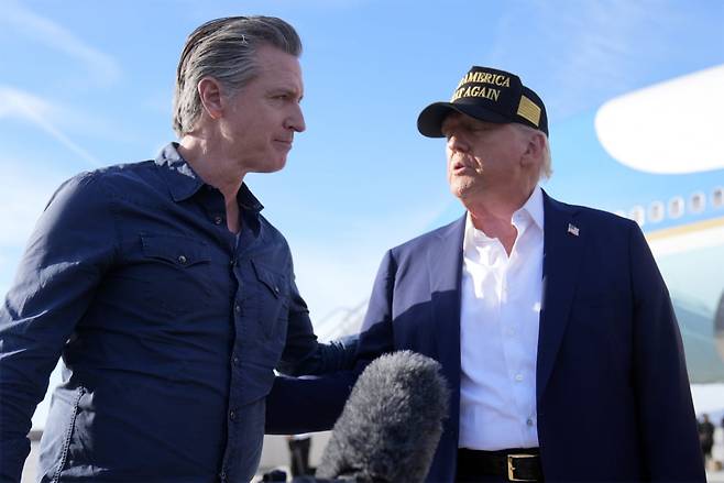 도널드 트럼프 미국 대통령이 2025년 1월 24일(금) 로스앤젤레스 로스앤젤레스 국제공항에 에어포스원을 타고 도착한 뒤 개빈 뉴섬 캘리포니아 주지사와 대화를 나누고 있다. 캘리포니아주는 2026년부터 기업에 스코프 3(총외부배출량)를 포함한 강력한 기후 공시를 의무화할 예정이다. 사진=연합뉴스