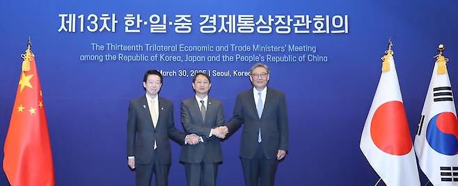 안덕근(가운데) 산업통상자원부 장관, 왕원타오(오른쪽) 중국 상무부장, 무토 요지 일본 경제산업성 대신이 지난 3월 30일 5년 만에 열린 한중일 경제통상장관회의에서 손을 맞잡고 있다. [사진 | 뉴시스]