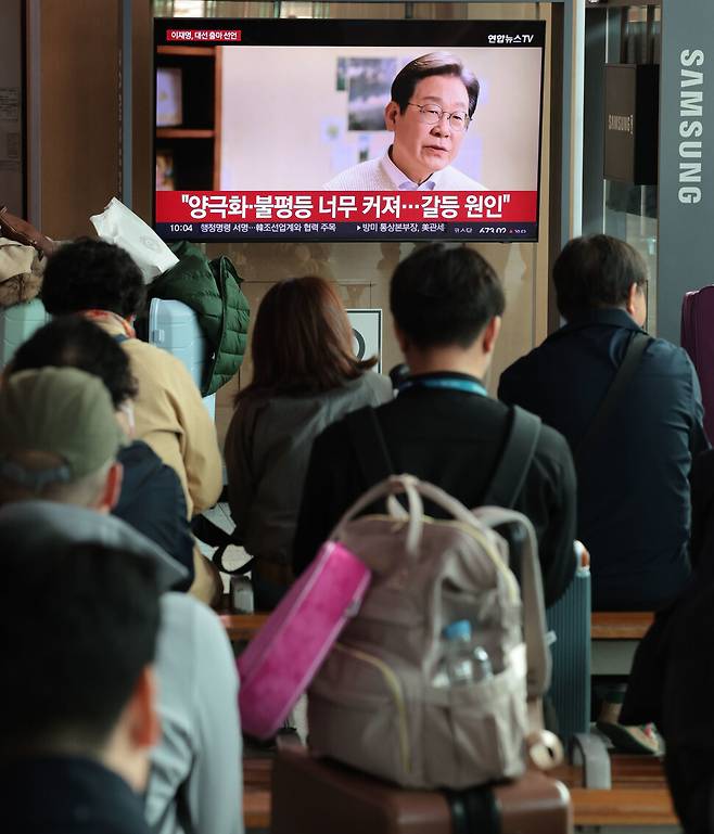 2025년 4월10일 서울역 대합실에서 이재명 전 대표의 대선 출마 영상을 지켜보는 시민들. 연합뉴스