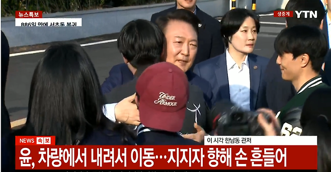 윤석열 전 대통령이 11일 오후 서울 서초동 사저로 이동하면서 사저 정문 앞에 차를 세운 뒤 내려서 지지자들과 일일이 악수하고 포옹을 하고 있다. YTN 뉴스영상 갈무리