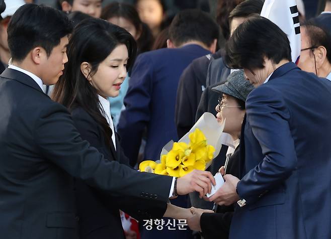 김건희 여사가 11일 서울 서초구 아크로비스타 사저로 향하며 꽃다발을 선물받고 있다.  정효진 기자