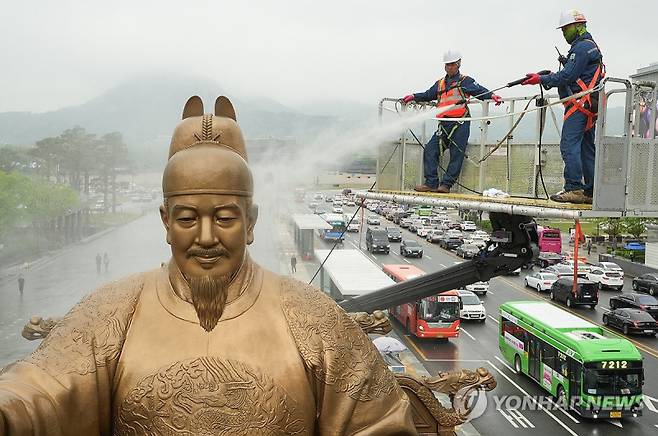 지난해 서울 광화문광장에서 서울시 관계자들이 세종대왕 동상을 세척하고 있다. 연합뉴스