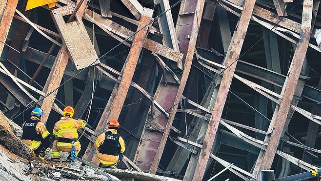 11일 오후 경기 광명시 일직동 양지사거리 인근 신안산선 복선전철 5-2공구 공사 붕괴 현장에서 소방대원들이 무너진 구조물을 살펴보고 있다. 지하 30여 m 깊이 터널이 내려앉으면서 철근과 자재 등이 뒤엉켜 있다. 경기도소방재난본부 제공