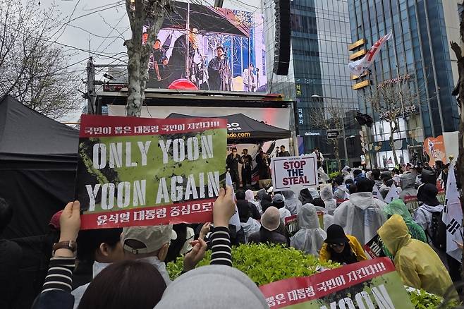 12일 극우 유튜버 안정권씨가 서울 서초동 교대역 인근에서 주최한 집회에 참여한 윤 전 대통령 지지자가 "Yoon Again" 피켓을 치켜들고 있는 모습. / 사진=정희원 기자