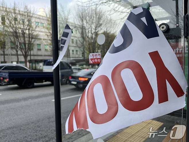 13일 오전 9시 30분쯤 서울 서초구 서초동 윤석열 전 대통령 사저 인근 버스정류장에 윤 전 대통령 지지자들이 붙여 놓은 피켓이 찢어져 바람에 나부끼고 있다.2025.4.13/뉴스1 김종훈 기자