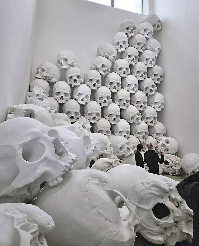 층고 14m 지하 전시장에 두개골 형상 100개가 천장 창문서부터 바닥으로 쏟아져 내리듯 쌓여 있다. 백색 두개골 하나당 무게 60㎏, 높이 1.2m에 달한다. /허윤희 기자
