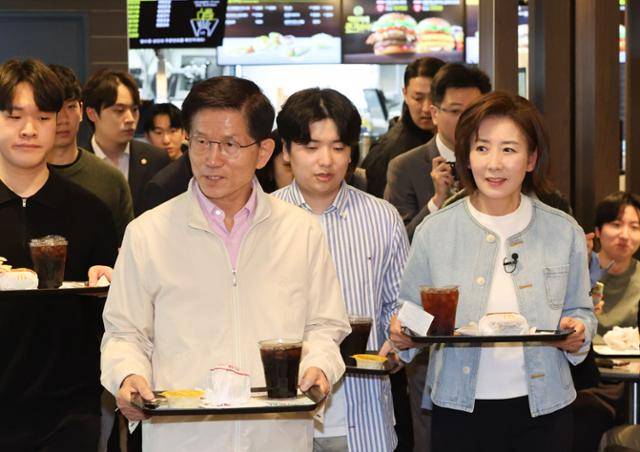 대선 출마를 선언한 김문수(왼쪽) 전 고용노동부 장관과 국민의힘 나경원 의원이 12일 서울 동작구 중앙대학교 내 패스트푸드 음식점에서 청년 간담회를 열기 앞서 주문한 음식을 들고 자리로 향하고 있다. 연합뉴스