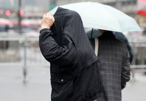 14일 오전 서울 종로구 광화문 네거리에서 한 시민이 자켓으로 머리를 가린 채 발걸음을 옮기고 있다. 뉴스1