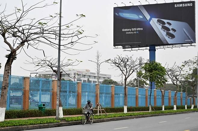 베트남 박닌성에서 오토바이를 탄 시민이 삼성전자 공장 앞을 지나고 있다. [AFP = 연합뉴스]
