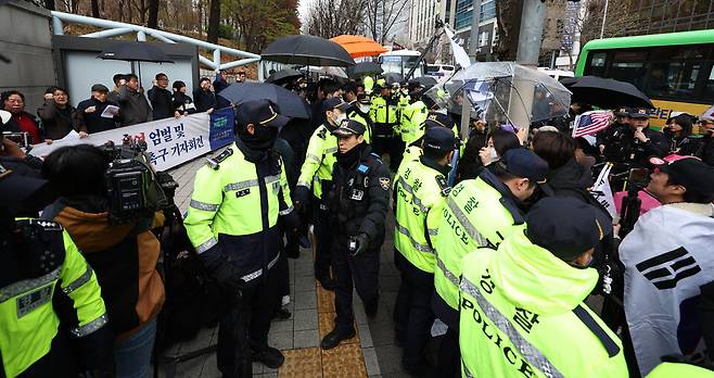 내란 우두머리 혐의로 기소된 윤석열 전 대통령의 첫 형사재판이 열린 4월14일 서울 서초구 서울중앙지방법원 앞에서 경찰 관계자들이 윤 전 대통령 엄벌 촉구 기자회견을 하는 시민단체와 윤 전 대통령 지지자들을 분리하고 있다. ⓒ 연합뉴스