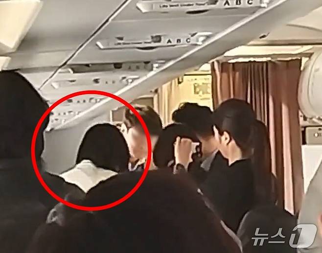 15일 오전 8시15분쯤 김포행 에어서울 RS902편 항공기에서 비상구 문을 연 피의자가 공항경찰대에 인계되고 있다.(독자제공. 재판매 및 DB금지)