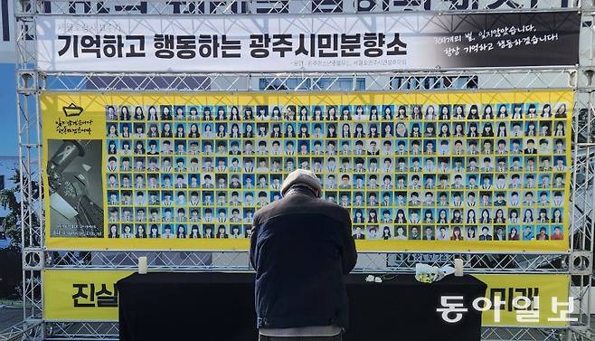 14일 세월호광주시민상주모임이 광주 동구 5·18민주광장에 마련한 세월호 시민분향소에서 한 시민이 헌화를 한 뒤 묵념을 하고 있다. 이형주 기자 peneye09@donga.com