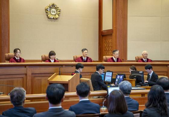 문형배 헌법재판소장 권한대행(가운데)이 지난 4일 서울 종로구 헌법재판소 대심판정에서 윤석열 대통령 탄핵심판 인용 결정문을 낭독하고 있다. 사진공동취재단