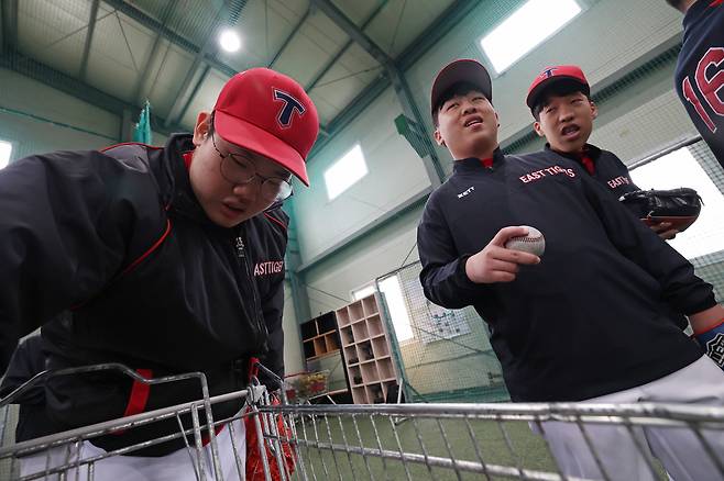 공 던지기 연습을 하기 위해 고민석, 이승윤, 이찬민 선수(왼쪽부터)가 카트에서 공을 하나씩 꺼내고 있다.