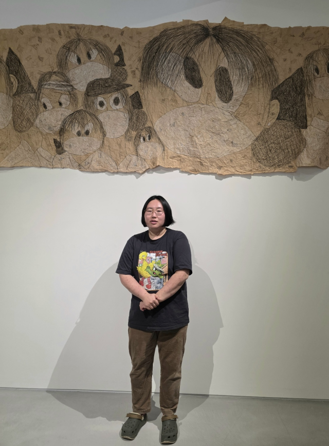 신민 작가가 자신의 작품 '유주얼 서스펙트' 연작이 걸린 전시장에서 작품에 대해 설명하고 있다. 김경미 기자