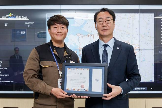 정명근 화성시장이 16일 동탄출장소에서 자원화시설의 폐금고에서 귀금속을 발견해 신고한 조성준(왼쪽) 주무관에게 표창을 전달하고 있다. 화성시 제공
