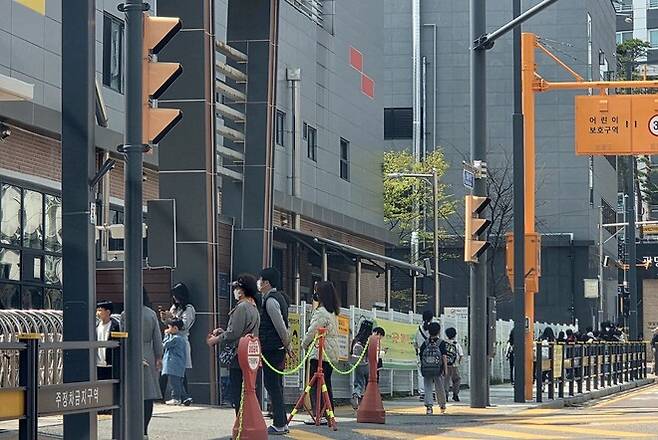 16일 경기도 광명시 신안산선 붕괴사고 인근 빛가온초등학교 정문에서 학부모들이 자녀를 기다리고 있다. 이 학교는 14∼15일 이틀간 휴업에 들어갔다가 이날부터 정상 운영에 들어갔다. 이정하 기자
