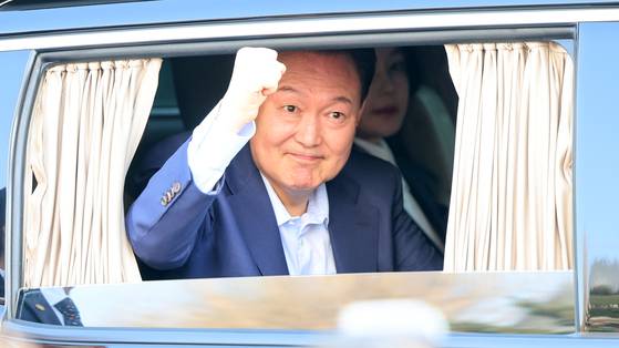 윤석열 전 대통령이 지난 11일 서울 한남동 관저를 떠나 서초동 사저로 이동하는 중 차량 밖으로 지지자들을 향해 불끈 주먹을 쥐고 있다. 민주당은 "개선장군 행세"라고 비판했다. 전민규 기자