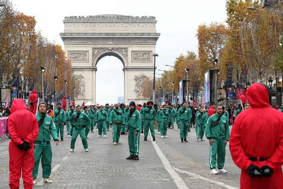 프랑스 파리 샹젤리제 거리에서 참가자들이 ‘오징어 게임’에 등장하는 무궁화 꽃이 피었습니다 게임에 참여하는 모습. AFP=연합뉴스