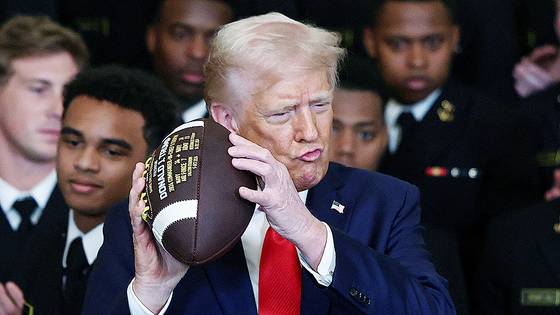 도널드 트럼프 미국 대통령이 15일(현지시간) 백악관에서 미국 해군사관학교 미식축구팀에 대한 트로피 수여식에서 자신의 이름이 적힌 공을 들고 포즈를 취하고 있다. 로이터=연합뉴스