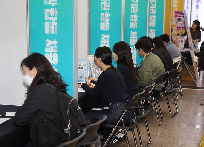 부산 혁신도시와 함께하는 ‘2025 지역인재 공공기관 합동 채용설명회’가 열린 8일 부산시 연제구 시청 로비에서 참가 취업준비생들이 고졸 채용지원 부스에서 맞춤형 상담을 하고 있다. [연합]