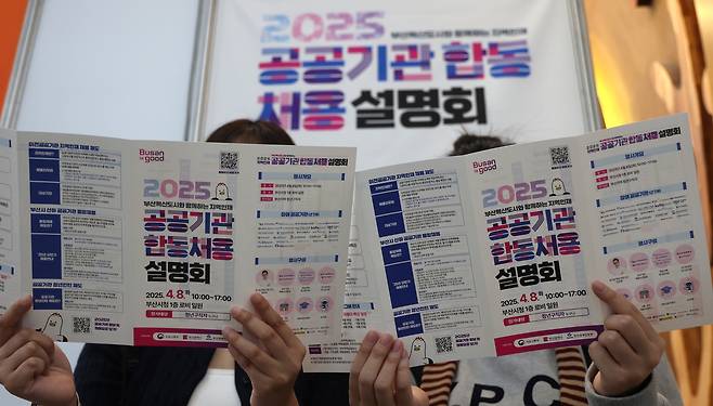 부산 혁신도시와 함께하는 ‘2025 지역인재 공공기관 합동 채용설명회’가 열린 8일 부산시 연제구 시청 로비에서 취업준비생들이 행사 안내 전단을 살펴 보고 있다. [연합]