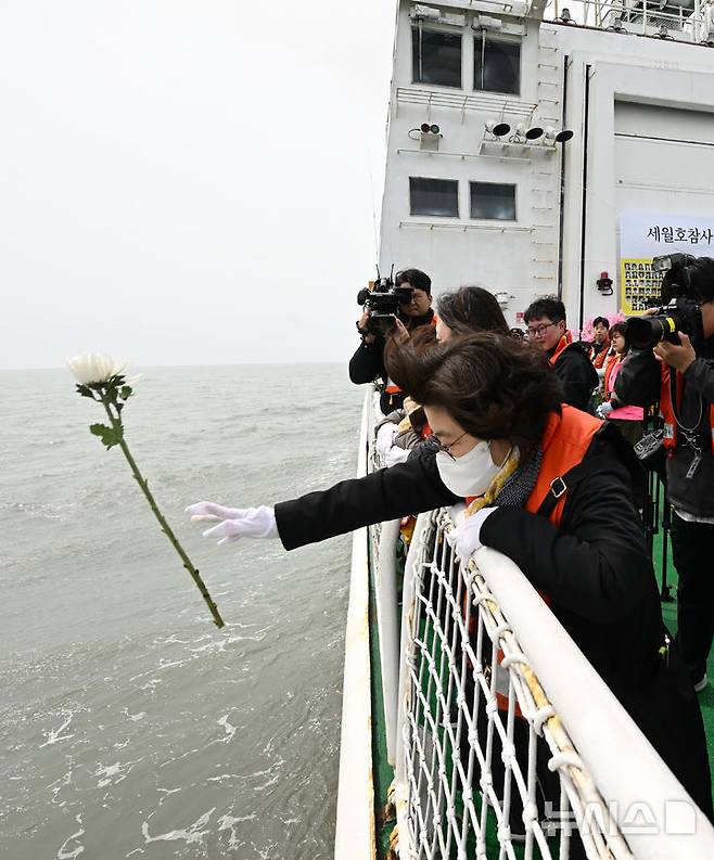 [진도=뉴시스] 김혜인 기자 = 세월호 참사 11주기인 16일 오전 전남 진도군 맹골수도에서 열린 선상추모식 중 세월호 참사 유족이 사고 해역에 희생자를 추모하는 국화를 헌화하고 있다. 2025.04.16. hyein0342@newsis.com