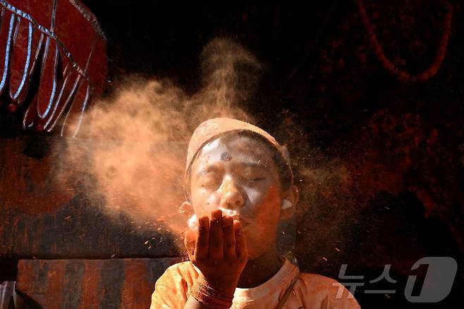 15일(현지시간) 네팔 카트만두에서 열린 신두르 자트라 축제에서 시민들이 주홍 가루를 뿌리며 축제를 즐기고 있다. ⓒ AFP=뉴스1