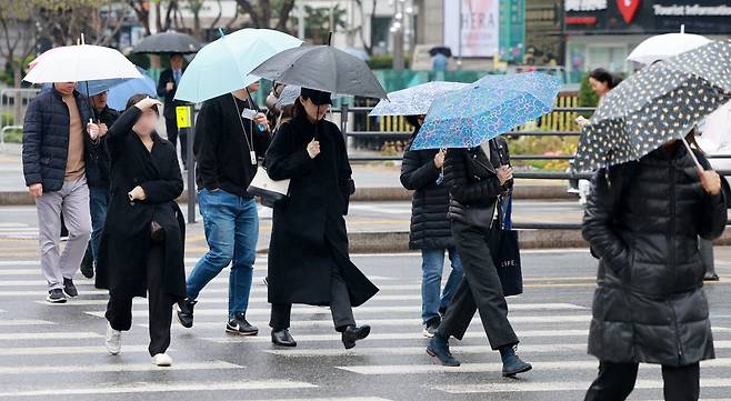 14일 오전 서울 종로구 광화문 네거리에서 우산을 쓴 시민들이 출근길을 서두르고 있다. 기상청은 이날 전국 대부분 지역에 비 또는 눈이 내리겠고, 돌풍과 함께 천둥·번개가 치고 일부 지역에는 싸락우박이 떨어질 수 있다고 밝혔다. 2025.4.14/뉴스1
