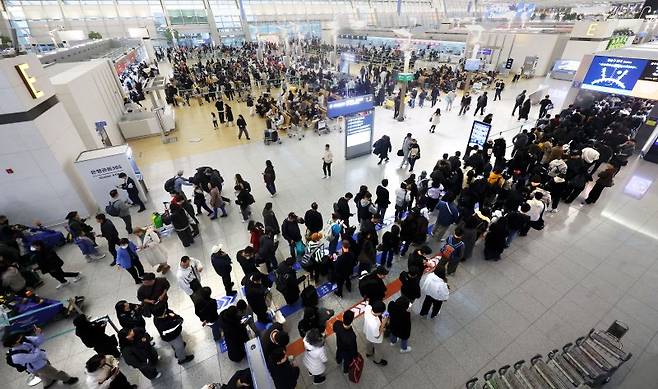 인천국제공항 제1터미널을 찾은 여행객들이 지난 1월 26일 탑승 수속을 위해 긴 줄을 서 있다. 뉴시스