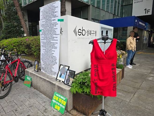 [서울=뉴시스] 고재은 수습기자 = 서울 성북구 하월곡동 일대 성매매 집결지, 이른바 '미아리텍사스' 에서 강제 철거를 당한 여성들이 17일 오전 성북구청 앞에서 천막농성을 벌이며 강하게 항의했다. 현장에는 '우리는 살고 싶다', '건물주는 각성하라'는 문구가 적힌 팻말과 현수막이 곳곳에 설치됐고, 붉은색 민소매 원피스가 성북구청 입구에 걸려 시위 상징물로 사용되기도 했다. 2025.04.17. jeko@newsis.com *재판매 및 DB 금지