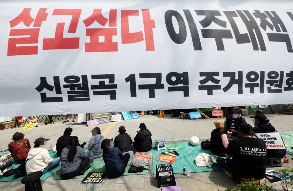 17일 서울 성북구청 앞에서 열린 미아리 성노동자 이주대책 마련 촉구 집회에서 참가자들이 현수막 아래에 앉아있다. 2025.4.17. 연합뉴스