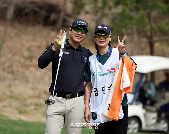 김민수가 17일 춘천 라비에벨 골프&리조트에서 열린 2025 KPGA 투어 DB손해보험 프로미오픈 1라운드 경기중 캐디를 맡은 아내와 다정하게 포즈를 취하고 있다. ｜KPGA 제공