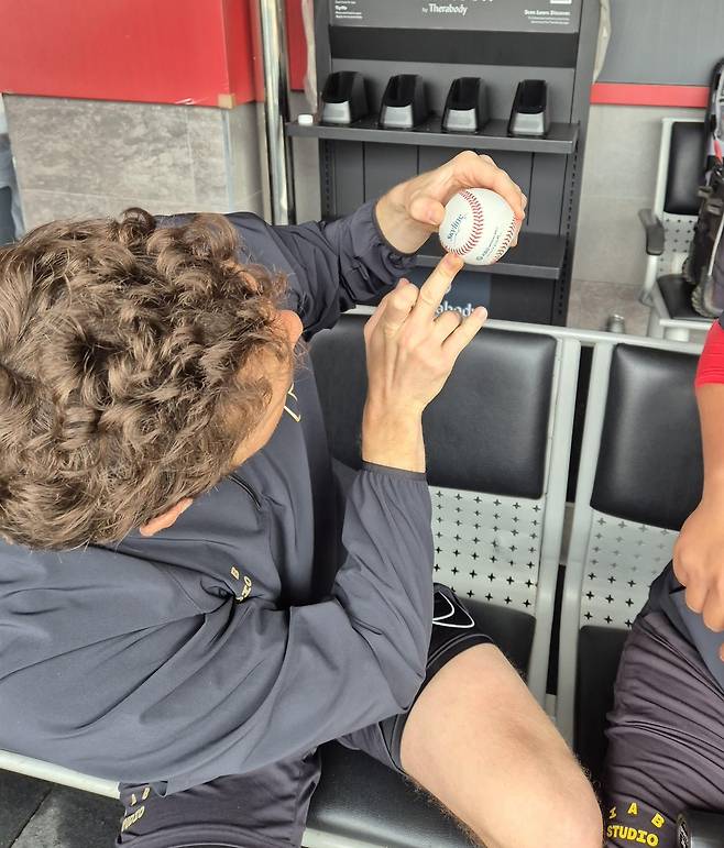 "중지로 이렇게 찍어 던져요" (광주=연합뉴스) 김경윤 기자 = KIA 타이거즈 제임스 네일이 16일 광주기아챔피언스필드에서 원심 패스트볼을 설명하고 있다. 2025.4.16. cycle@yna.co.kr