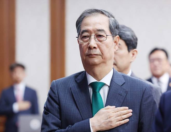 한덕수 대통령 권한대행 국무총리가 18일 정부서울청사에서 열린 국무회의에서 국기에 경례하고 있다.  [대통령실통신사진기자단] 연합뉴스