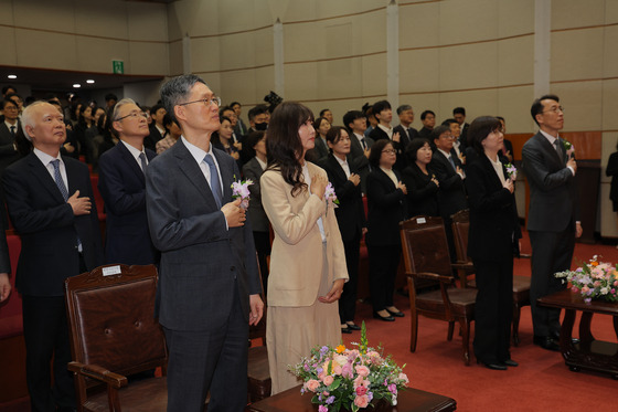 18일 오전 서울 종로구 재동 헌법재판소 대강당에서 열린 문형배·이미선 헌법재판관 퇴임식에서 참석자들이 국민의례를 하고 있다. 퇴임하는 문형배, 이미선 재판관은 각자 배우자와 함께 참석했다. 뉴스1