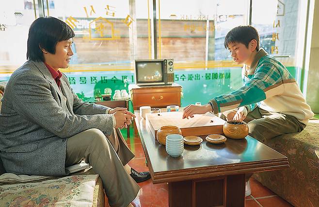 영화 ‘승부’ 속 조훈현 국수(이병헌)와 어린 이창호(김강훈)이 ‘이시계점’에서 대국을 펼치는 장면. [바이포엠스튜디오]
