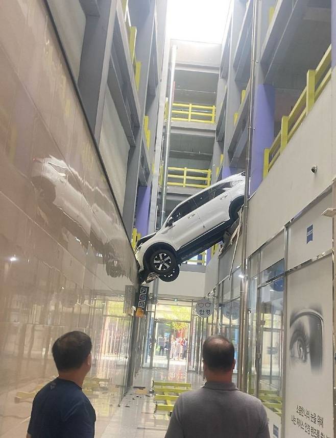 [순천=뉴시스] 김석훈 기자 = 18일 오후 전남 순천시 한 상가 건물 주차장 에서 SUV승용차가 건물 사이에 걸려있다. (사진=독자제공)  2025.04.18. photo@newsis.com *재판매 및 DB 금지