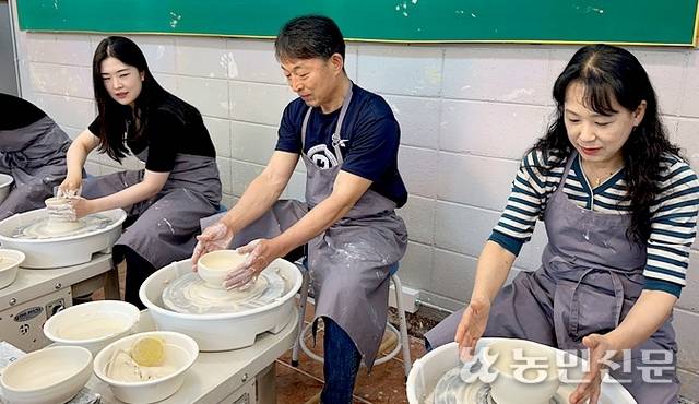 물레로 도자기를 빚는 체험객들.