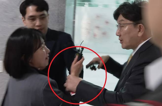 지난 16일 서울 여의도 국회에서 열린 헌법개정토론회 행사가 끝난 뒤 질문하는 뉴스타파 기자의 손목을 잡은 채 끌고 가는 국민의힘 권성동 원내대표(오른쪽). 뉴스타파 유튜브 캡처