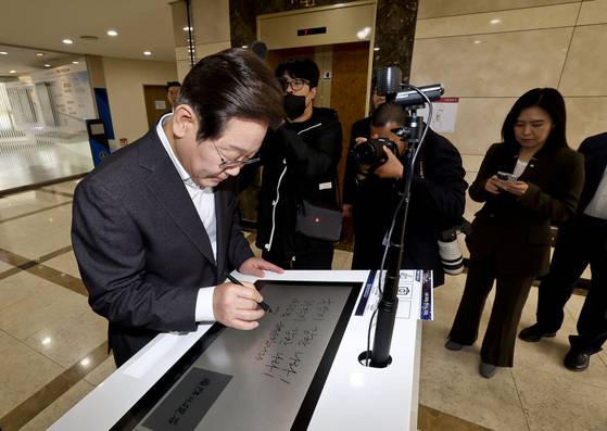 이재명 더불어민주당 대선 경선 후보가 지난 17일 대전광역시 유성구 국방과학연구소(ADD)에서 열린 현장간담회에 앞서 방명록을 작성하고 있다. 국회사진기자단