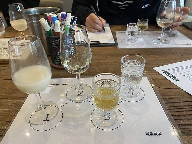 Traditional drinks are prepared for blind-tasting during the hands-on makgeolli class at Jasaeng-jeonsul on Sunday. (Lim Jae-seong/The Korea Herald)