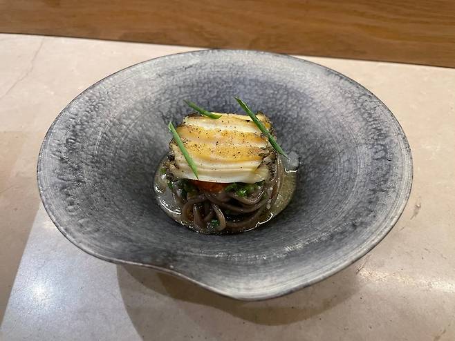 Memilmyeon, NAE:UM's signature dish made of buckwheat noodles, white kimchi and Jeju abalone (Hong Yoo/ The Korea Herald)