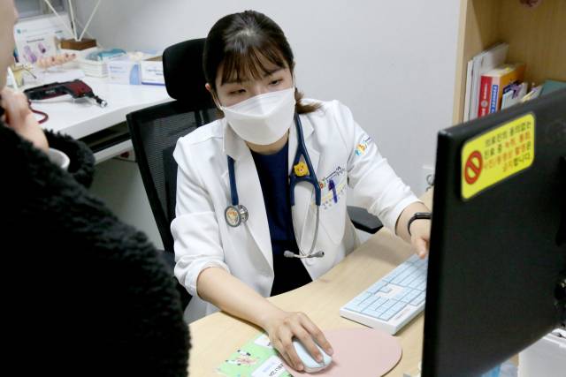 서민지 성북우리아이들병원 친구클리닉 진료과장이 13일 오후 10시경 어린 자녀의 폐렴 의심 증상으로 찾아온 보호자에게 엑스레이 검사 결과에 대해 설명하고 있다. 사진 제공=우리아이들의료재단