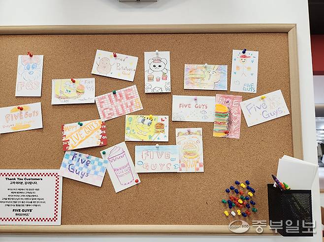 파이브가이즈 광교 내 어린이 방문객이 그린 그림이 게시돼 있다. 이보현 기자