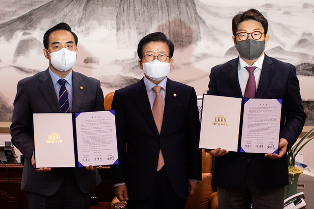 박병석 국회의장(가운데)과 박홍근 더불어민주당(왼쪽), 권성동 국민의힘 원내대표가 2022년 4월22일 오후 국회에서 ‘검찰의 수사-기소권 분리’(검수완박) 법안과 관련한 국회의장 중재안에 합의한 뒤, 서명을 마친 합의문을 들어 보이고 있다. 공동취재사진